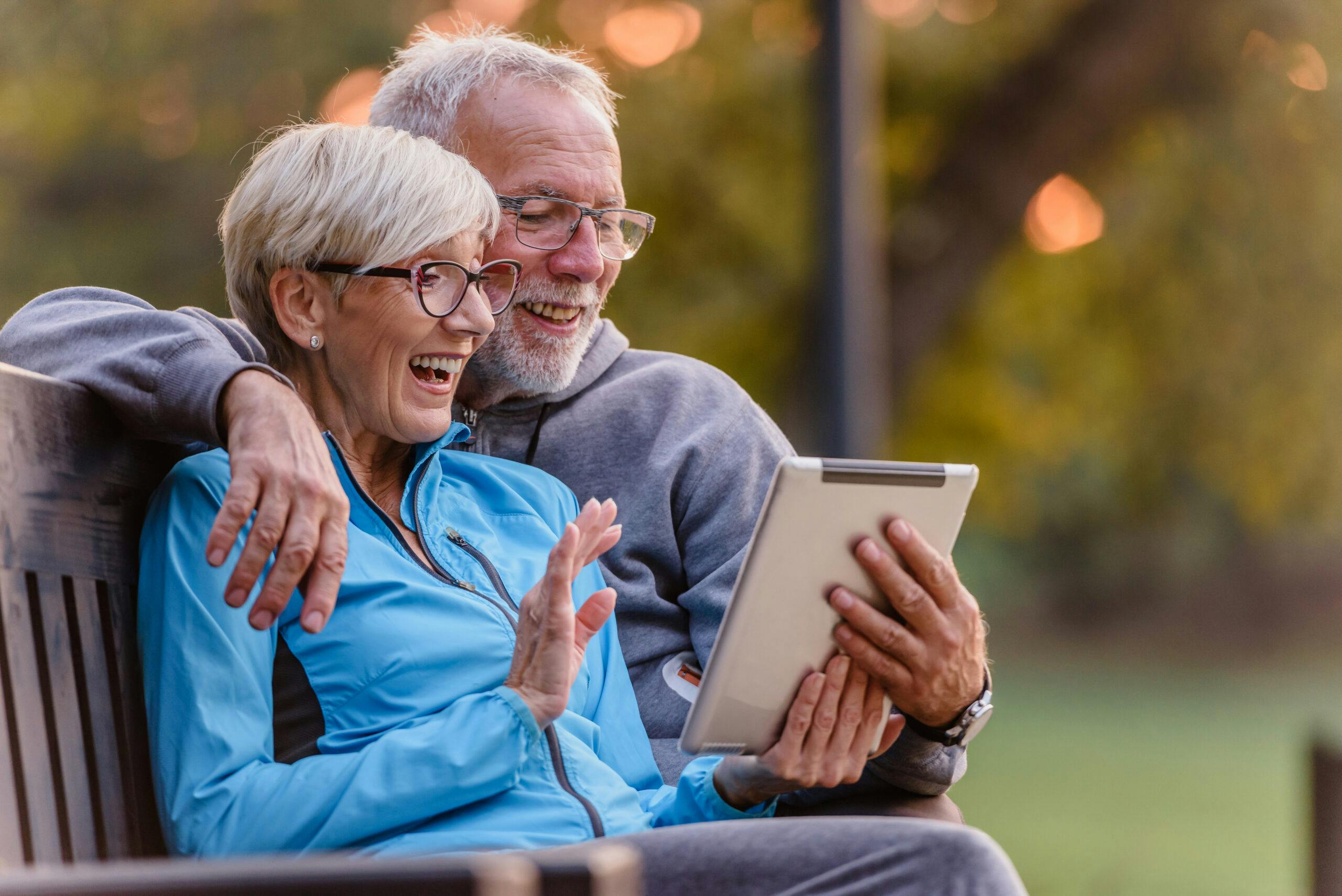 Older couple smiling at tablet