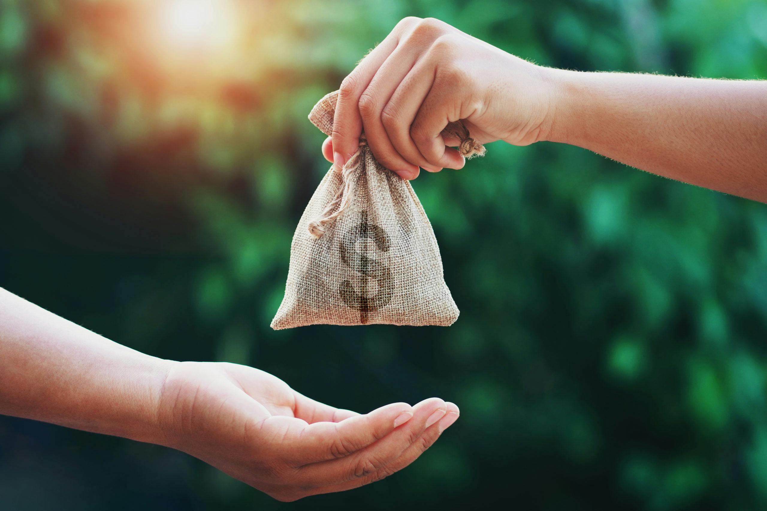 Photo of hand giving money to another person